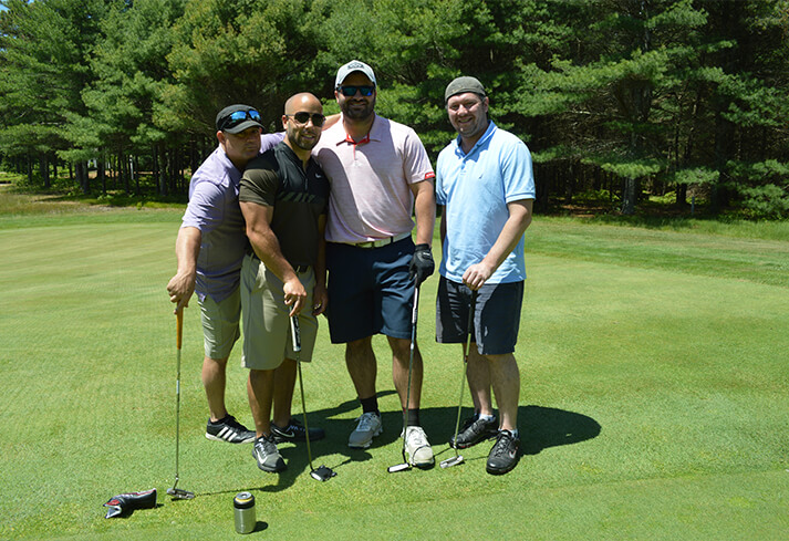 Four men standing on a putting green