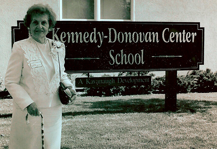 Older lady standing in front of a building.