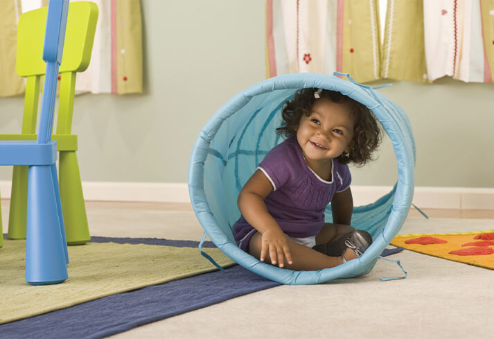 Child playing in a toy tube.