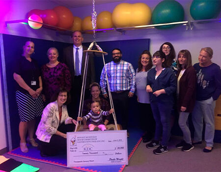 Adults and one baby posing in a room with a large check