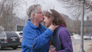 Woman kissing the forehead of a young girl