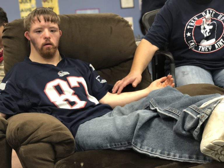 Adult male wearing a football jersey sitting in a recliner.