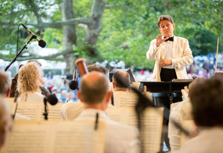 Orchestra playing with the conductor facing them